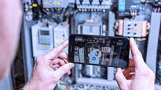 Someone is holding a smartphone to operate the service app miRemote